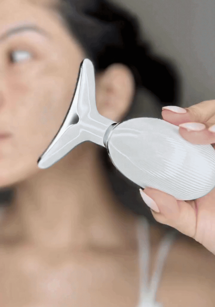 Anti-Wrinkle 4-in-1 EMS facial device being used on the cheek for a firming massage